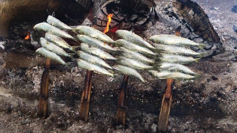 Sardines on sticks on fire are fried in a boat. Typical "espetos" food of Spain, Costa del Sol, Malaga. Traditional food.