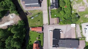 Descending top-down drone footage of a single athlete running down a street in a residential area. Filmed in realtime.