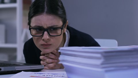 Unmotivated stressed office worker looking through papers, work overload closeup