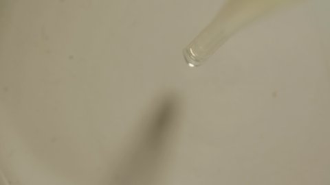 Clear Transparent Liquid Drops from Pipette on Ground