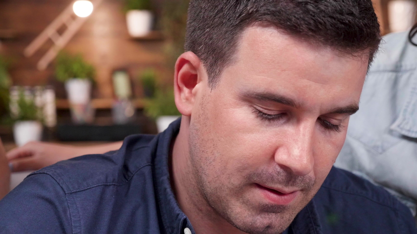 Revealing shot of creative team working and debating in front of the computer. They are in a cozy office. Slow motion shot