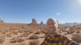 Traveling young man taking selfie portrait in USA at Monument Valley; Man enjoying vacations in America 