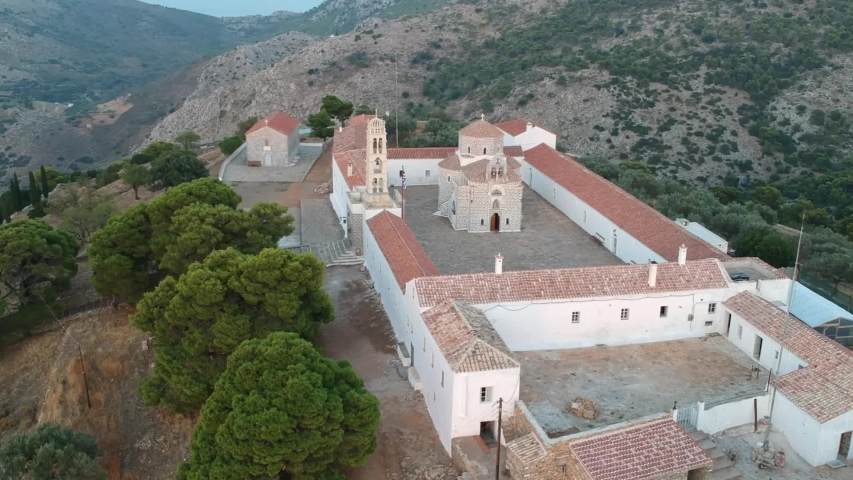 Old monastery building in the mountains in Greece. Square, in the hills with green trees. Aerial view. 