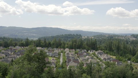 Issaquah Highlands Washington Aerial View New Homes Surrounded by Natural Beauty of Nature Forest Hillside and Seattle Skyline Background