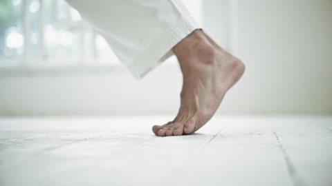 Man Leg In White Kimono On White Floor. Training Martial Arts.Selective Focus On Foot. Healthy Lifestyle Concept.