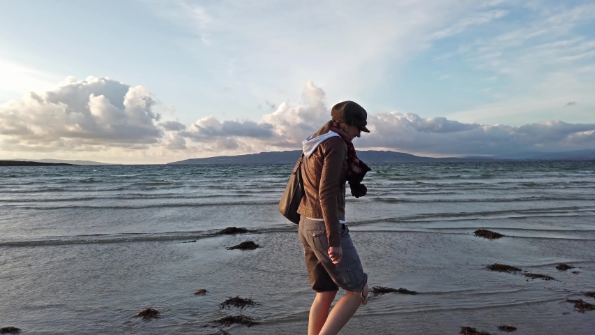 Lady running down the beach during sunset.