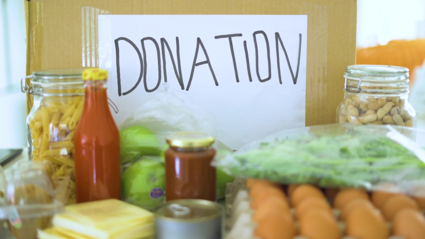 Donation concept. Cardboard box and foods for donation. Shot in 4k resolution Royalty-Free Stock Footage #1033586765