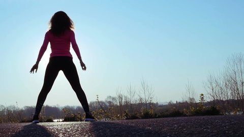 athletic woman goes in for sports on the river bank at sunrise. slow motion