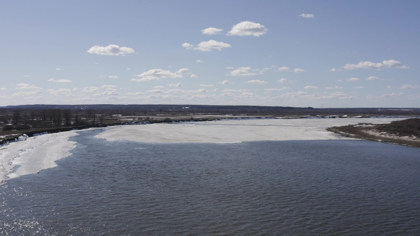 Flying drone over the ice floating on the river Oka