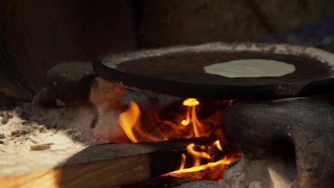 Mexican woman from Cuetzalan making authentic tortillas by hand in a typical “Comal” pan.