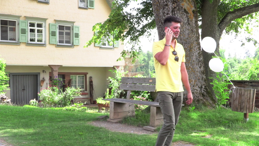 Young man talking on the phone on the street sitting on a bench