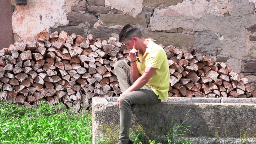 Portrait of a young man sitting on the nature near the wood