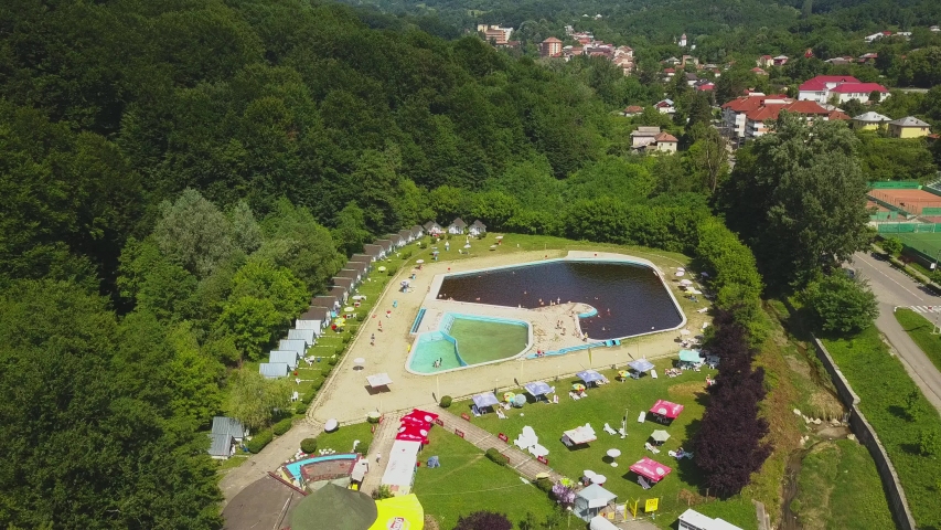 Topview from a drone over the pool surrounded by green trees. Herculane baths, Romania.