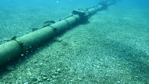 a pibe scenery underwater on sandy bottom dirty and pollution pipe line