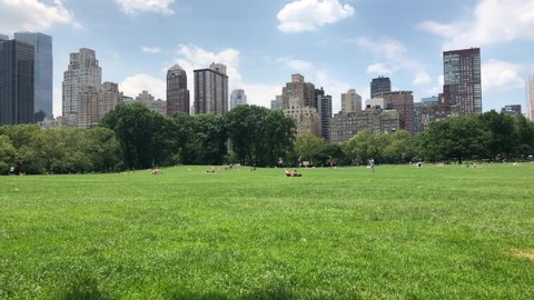 NEW YORK CITY crowd on a sweltering hot summer day in Central Park in New York. Central Park is a public park at the center of Manhattan that opened in 1857, on 778 acres of city-owned land.