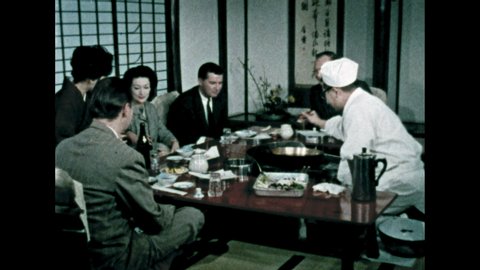 1960s: Plate of raw seafood and vegetables. Chef dips seafood in batter and then into hot oil. Chef places tempura on diner's plates.