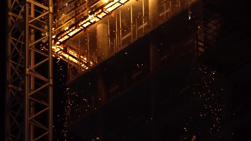 Building in Warsaw is burning. Sparks are spraying down in slow motion