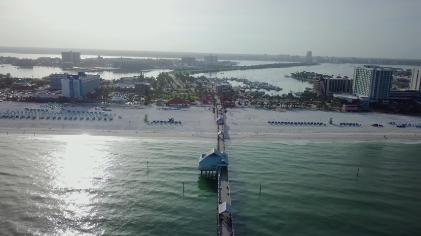 Aerial shot of a sunrise over a beach pier.