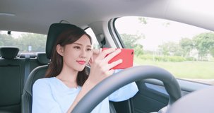 Asian woman experience to riding an autonomous self driving car and watch video by smart phone