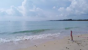 Landscape view of the white sea sand beach in summer daytime with some wave and wind blowing in Phuket, Thailand - in slowmotion 4k UHD video