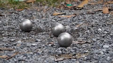 The old Petanque French balls was thrown to clash with the target to get out, at the rough petanque field,Petanque French game, Bangkok Thailand, July 2019