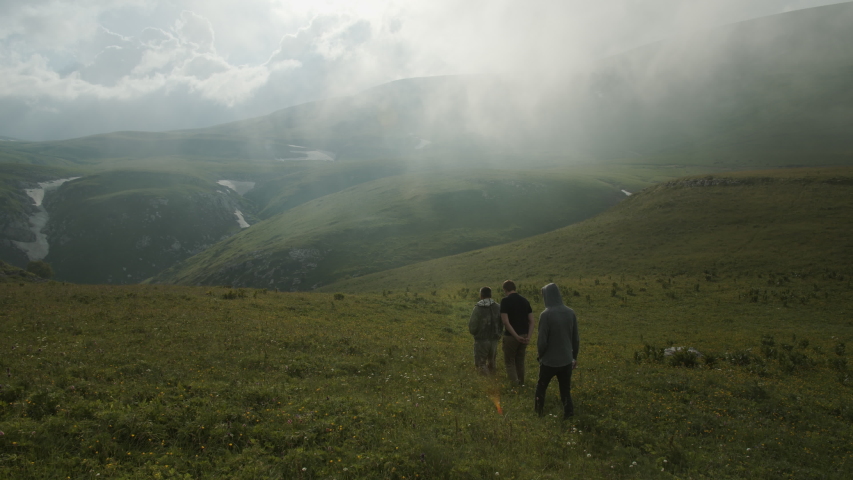A group of people walking through mountain meadows