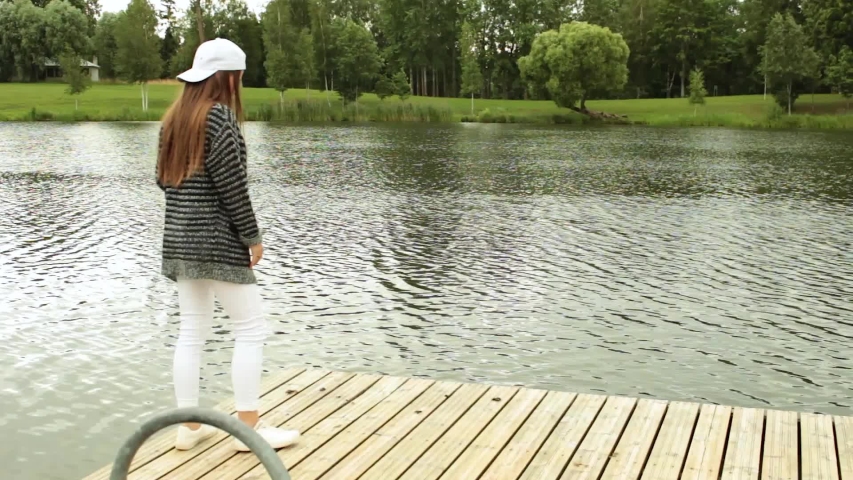 Girl walking on footbridge next to a lake