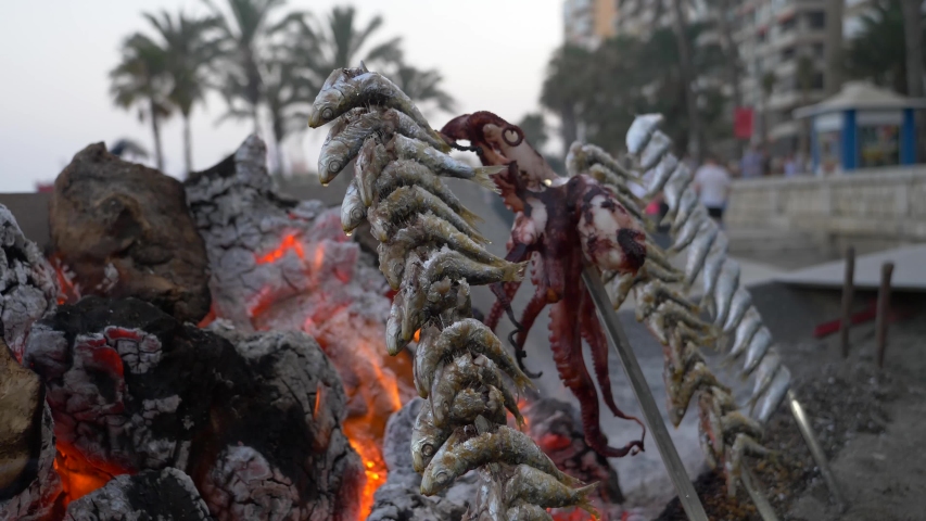 Sardines and octopus in a stick in front of the fire being cooked 