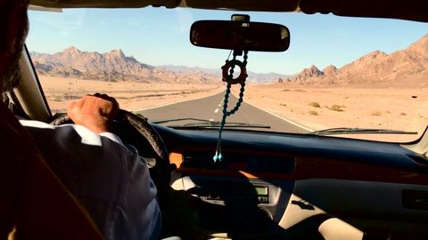 dahab, Egypt - 04 28 2019: View from a taxi and it's driver in the arabian desert.