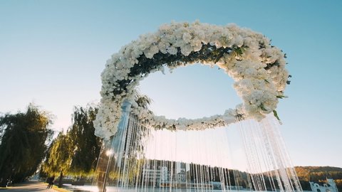 Concept Of Wedding Decor, Street Decoration, Wedding Arch Is Decorated With Flowers. Wedding Arc In The Form Of Circle.