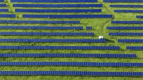 Flight over the solar power station. Aerial drone video footage looking down on rows of blue solar panels in a renewable energy farm. Alternative energy concept. HD 1080p