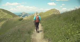 Happiness Woman tourist traveler walking on the top of mountain in summer sunny day under sun light. Beautiful mountains landscape view. 4K slow motion video