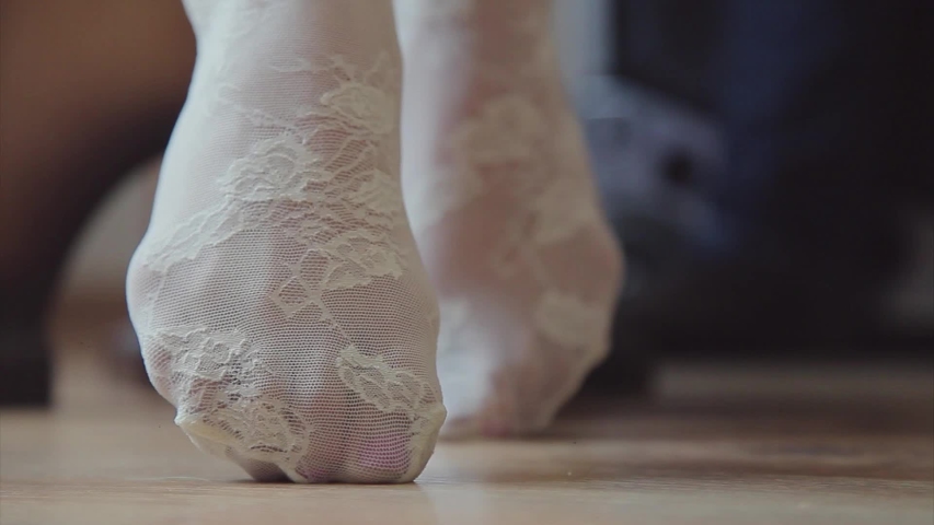 the concept of hygiene, vein health, skin care, pedicure, fungus prevention - women's feet in white stockings closeup. soft, selective focus. girl dancing