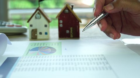 Real estate agent investment report concept : Businessman checking documents and signature in loan graph document home on mortgage, contract in property financial project on desk office. Signing focus