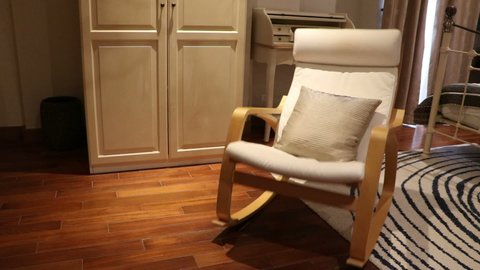 Wooden rocking chair with pillow in bedroom swing (fast to slow) by nobody in there