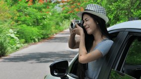 Happy asian women taking pictures in the car on the road. Natural background sunlight, daylight and tree. summer holiday travel trip concept. Slow Motion Video Clip