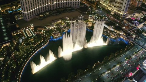 Fountains of Bellagio, The Strip. Las vegas. Nevada. Jul 2019. Aerial 4K. Spectacular view of lighting performance in casino area at night. Fountains at Bellagio Las Vegas dance - view from above.