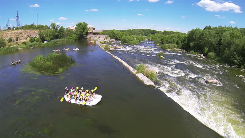 White boat with tourists on river. Aerial  view of rafting team
