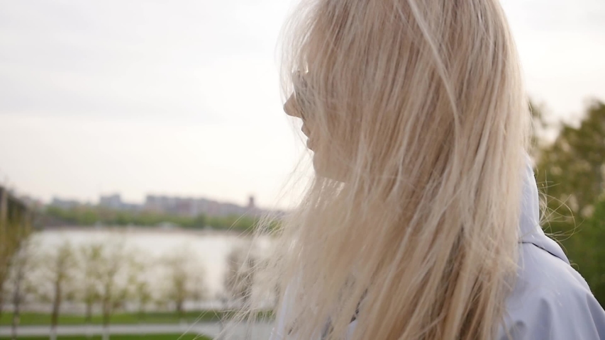 Young beautiful woman in sunglasses. Pretty blonde on a walk. Slow motion