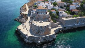 Aerial birds eye view video taken by drone of picturesque port entrance memorial in island of Hydra or Ydra, Saronic gulf, Greece