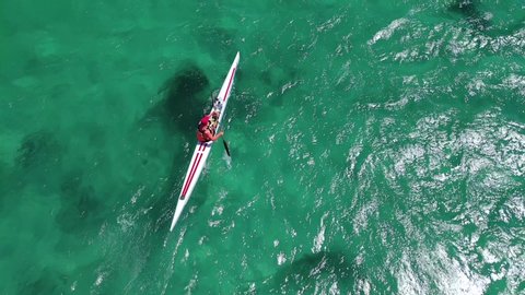 Aerial drone tracking video of fit man practising sport canoe in tropical crystal clear Mediterranean emerald sea : vidéo de stock