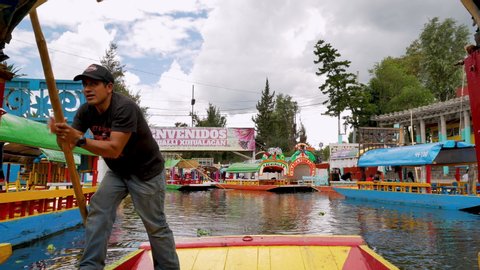 Xochimilco, Mexico City, June 25, 2019 - Trajinero row the trajinera for tourists in Nativitas channel in Xochimilco
