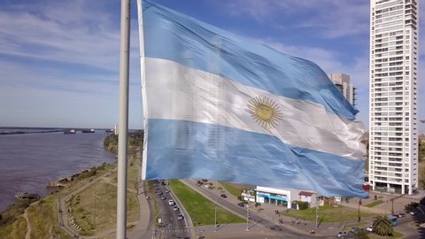 Rosario, Argentina, Jul 2019 - Aerial Drone Scene of Rosario City Skyline and Parana River with Argentinian Flag and Skyscrapers in Business District. Camera Moves Left.
