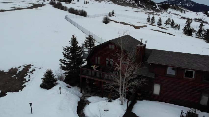 Ariel views overlooking a log home during the winter.