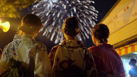 Karatsu, Japan - July 14, 2019: Japanese girls wearing kimono viewing fireworks display during summer holiday in Karatsu, Saga Prefecture