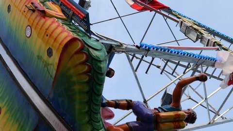 Bottom view under move and swing of Green Dragon Pirate Ship Ride with angular movement. Famous amusement ride for carnival, fun fair