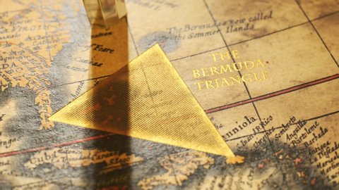 Famous Bermuda triangle marked with golden ink on an old, vintage map. A sign marks the spot of mysterious disappearing and ship disasters. Retro compass malfunctioning, can't find the right direction