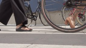 Close up of legs and feets of people waking on a busy street. Slow motion video.