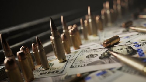 Countless ammo bullets standing on a pile of money. Cash wads in the background and dollars on the floor. Camera moving sideways in an endless, seamless looping animation. Wealth, force and corruption