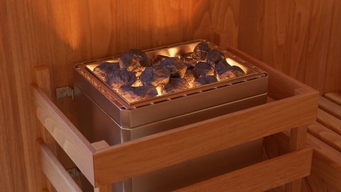 Traditional sauna accesories inside of empty sauna. Interior of wooden Finnish sauna, spa room for deep relaxation. Comfortable wooden room with hot glowing stones for maintaining high temperature.
